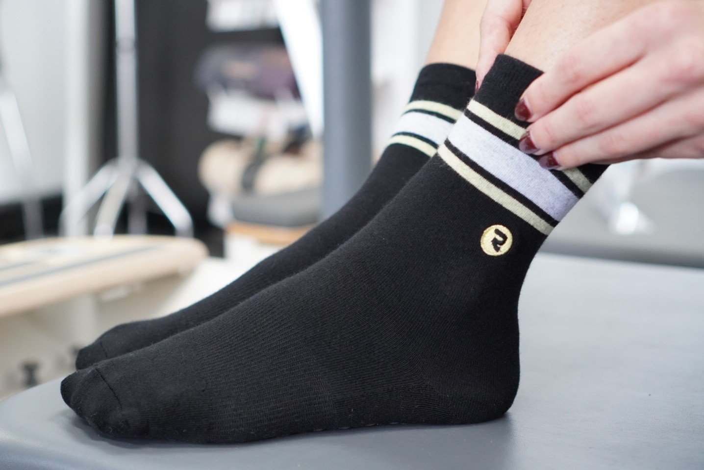 RESISTA Pilates Crew Grip Socks Black'n'Gold Hoops model wearing it on pilates reformer